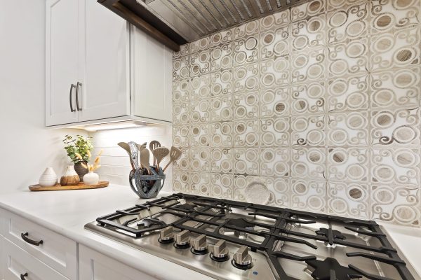 Custom range backsplash with white cabinets in new construction