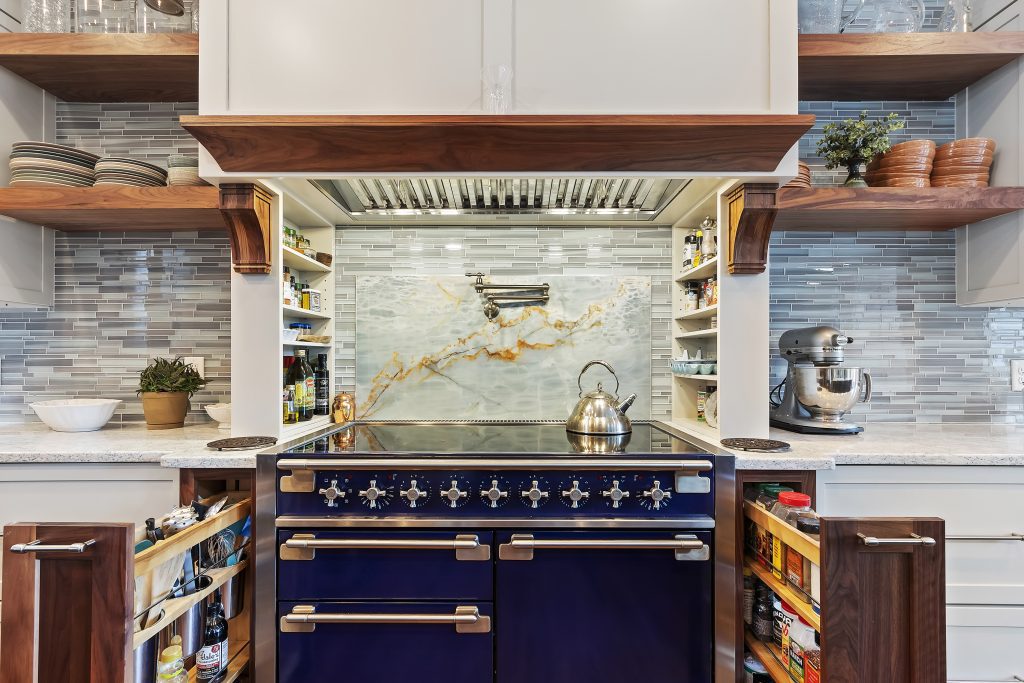 Custom kitchen renovation with blue range, pot filler and pull out spice cabinets